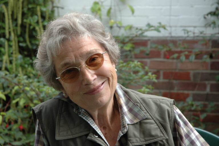 A smiling older woman in a garden