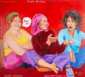 Three women sit on the floor, talking