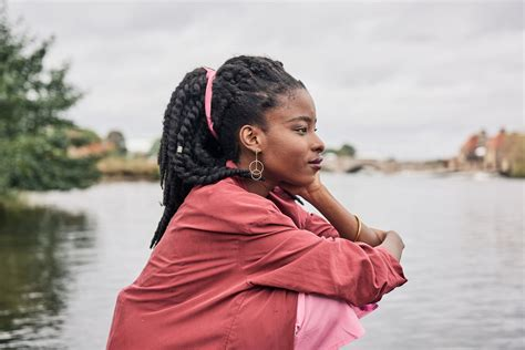 A young woman sitting by water