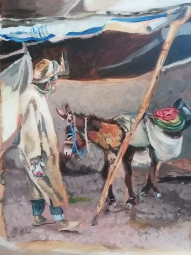 A man standing by a laden donkey